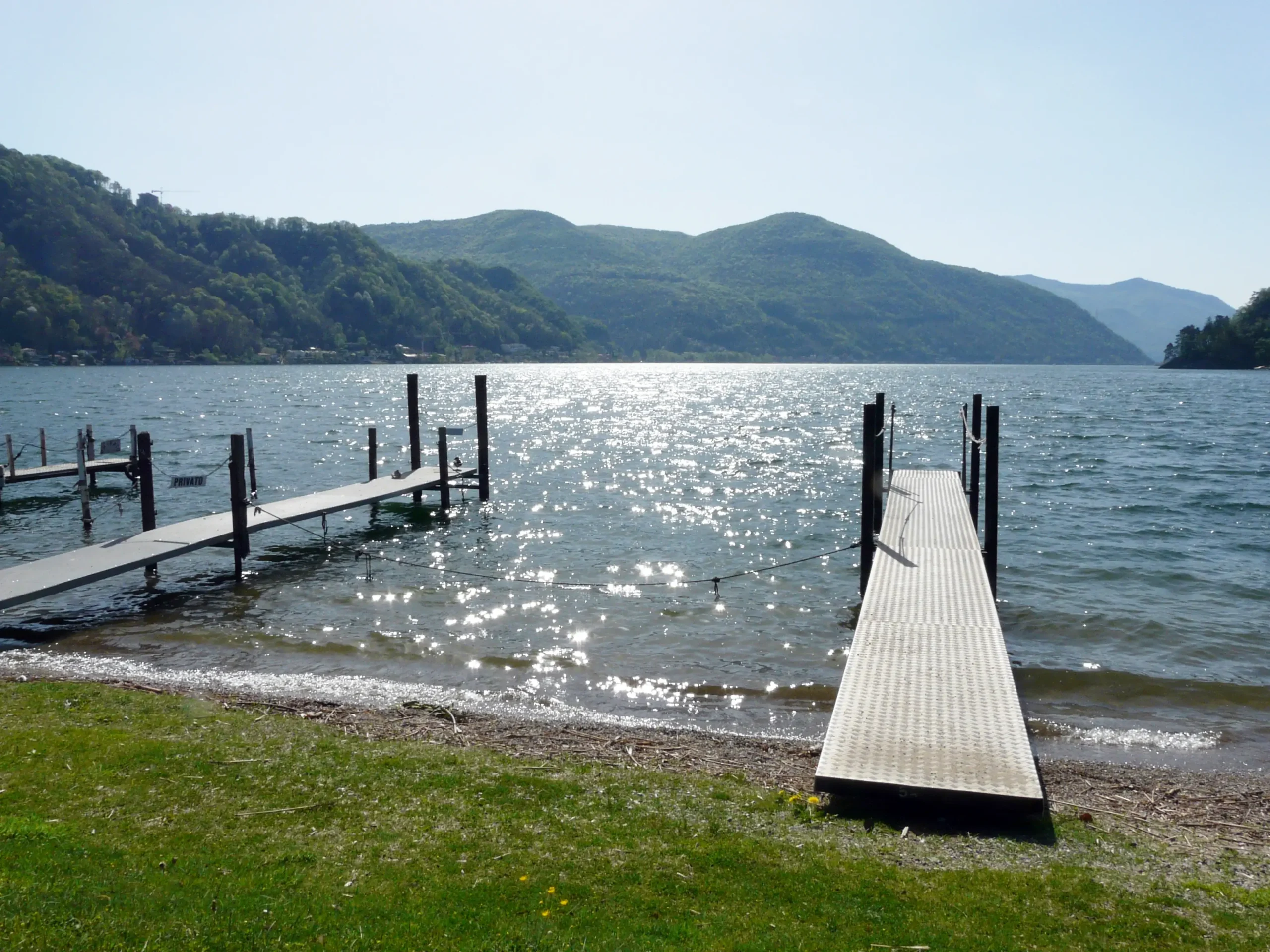 Lugano in a day: panoramic view from Caslano's lakefront towards Monte San Salvatore and Monte Brè